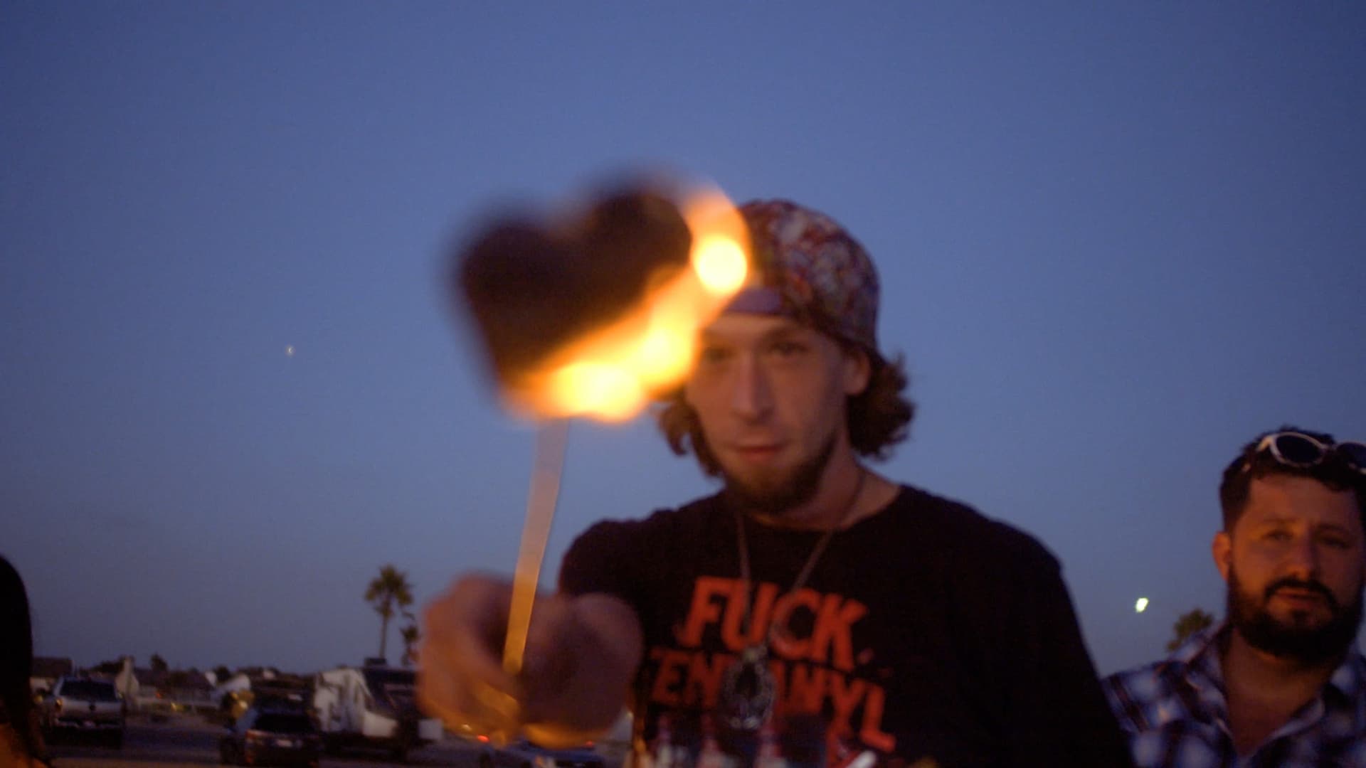 Client roasting a toasted marshmallow during a nighttime campfire.